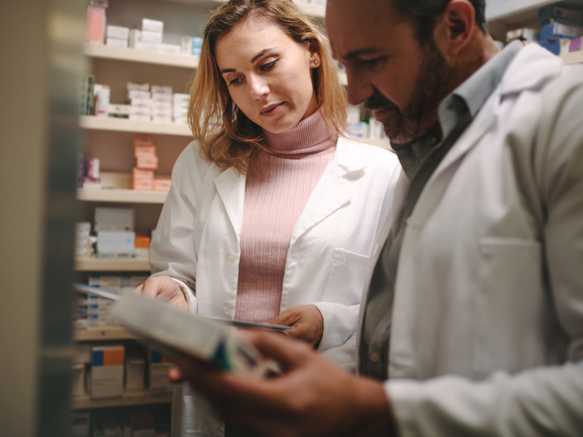 A man and woman in a pharmacy shop examining medicine