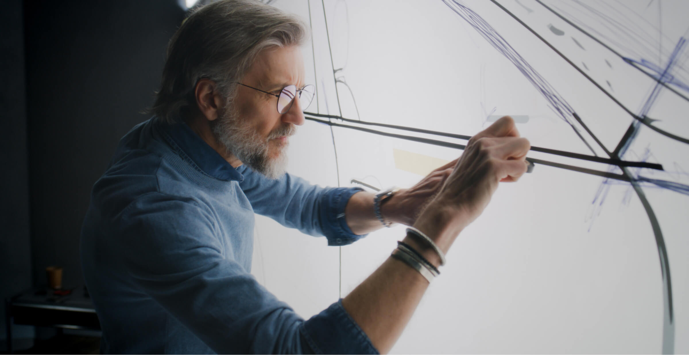 Experienced designer drawing on a whiteboard, conceptualizing innovative design ideas.