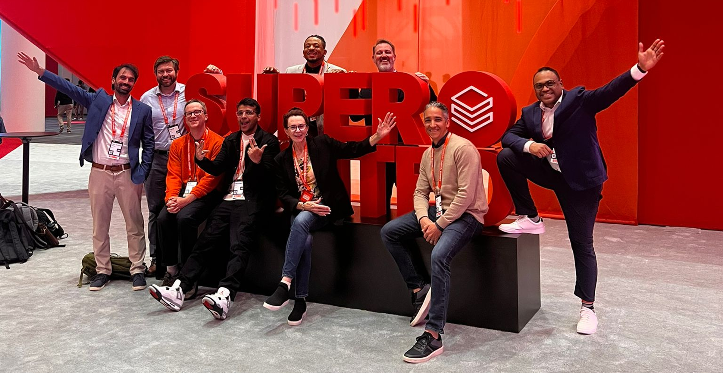 A group of friends smiling and posing in front of a large sign, capturing a fun moment together.  