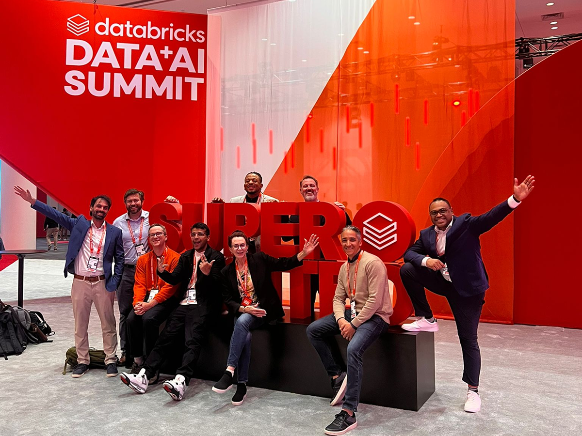 A group of friends smiling and posing in front of a large sign, capturing a fun moment together.  