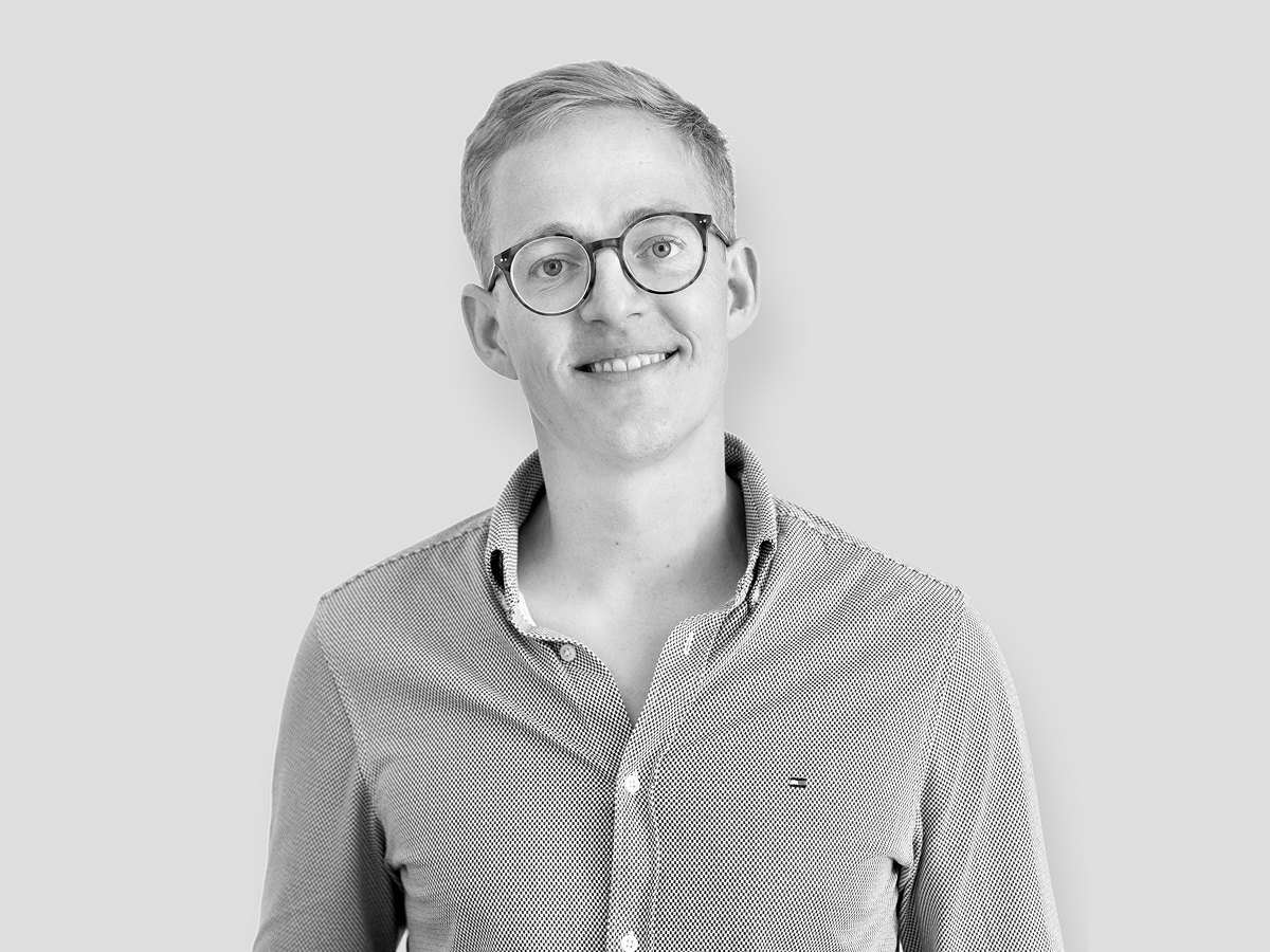 A smiling man wearing glasses and a shirt, exuding a friendly and approachable vibe.  