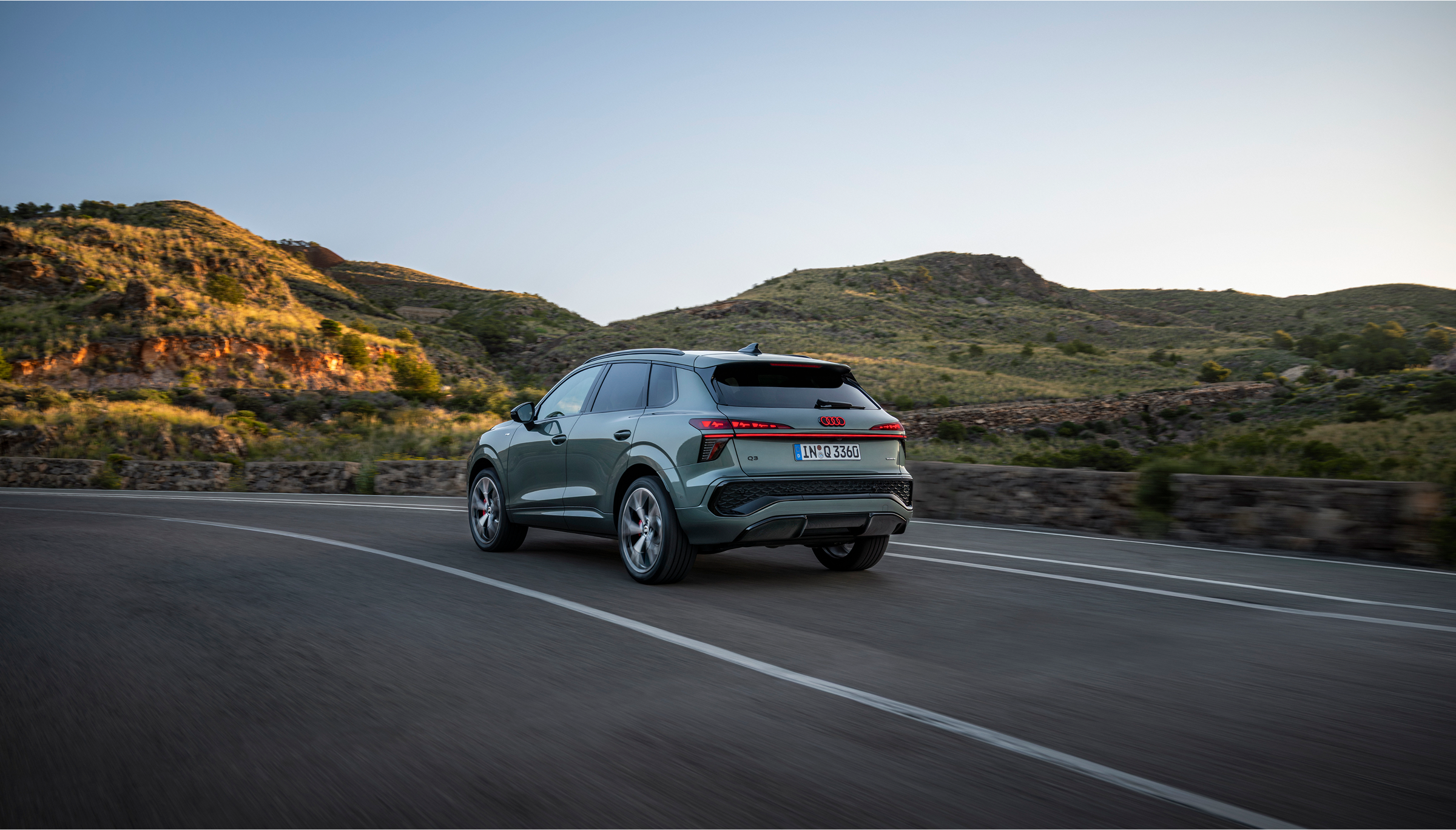 A 2021 Volkswagen Koncept SUV navigating a winding mountain road surrounded by lush greenery and rocky cliffs