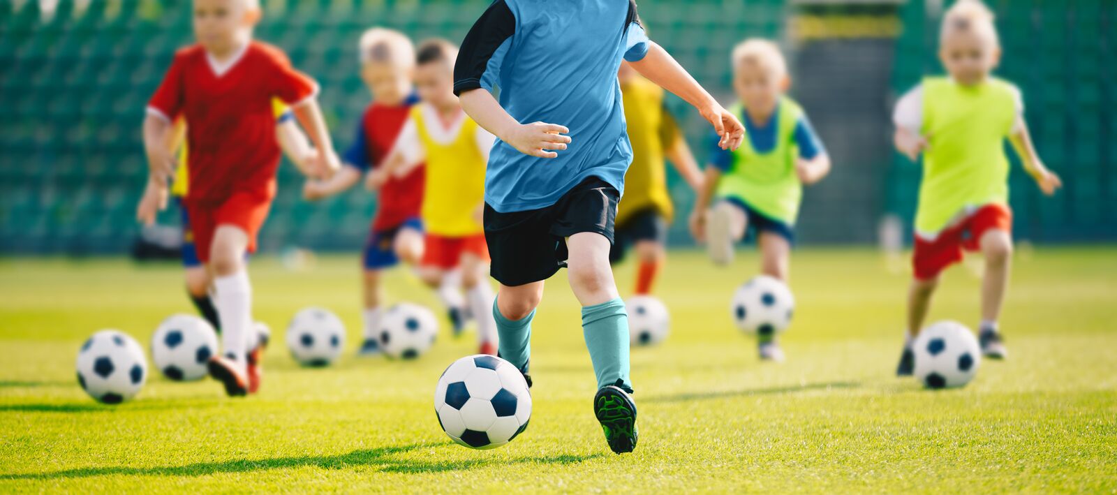 A group of children running soccer drills