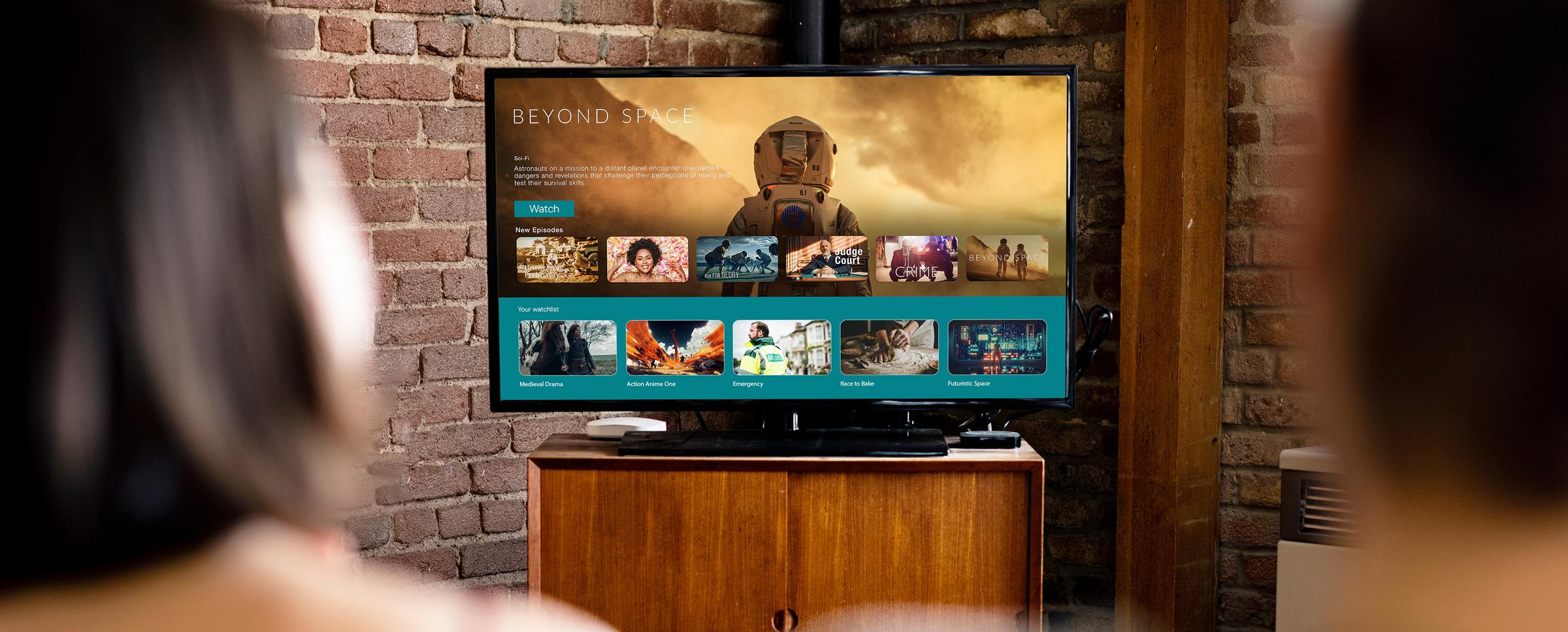 Two people sitting on a couch, watching a movie on a large television in a cozy living room setting.