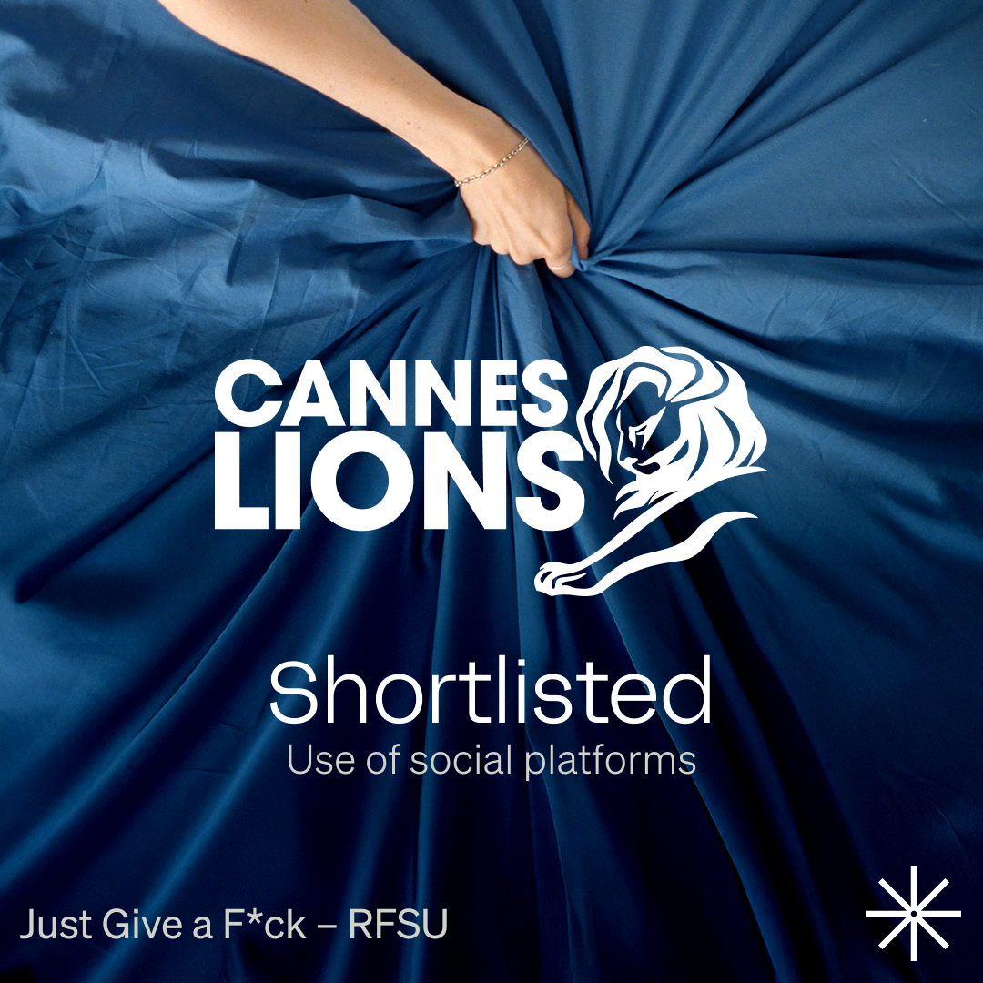 A hand pinches the center of a billowing dark-blue sheet, creating dramatic folds. Overlaid in bold white lettering are the Cannes Lions lion logo and the words “CANNES LIONS,” followed by the caption “Shortlisted – Use of social platforms” and the campaign title “Just Give a F*ck – RFSU” in the lower corner.