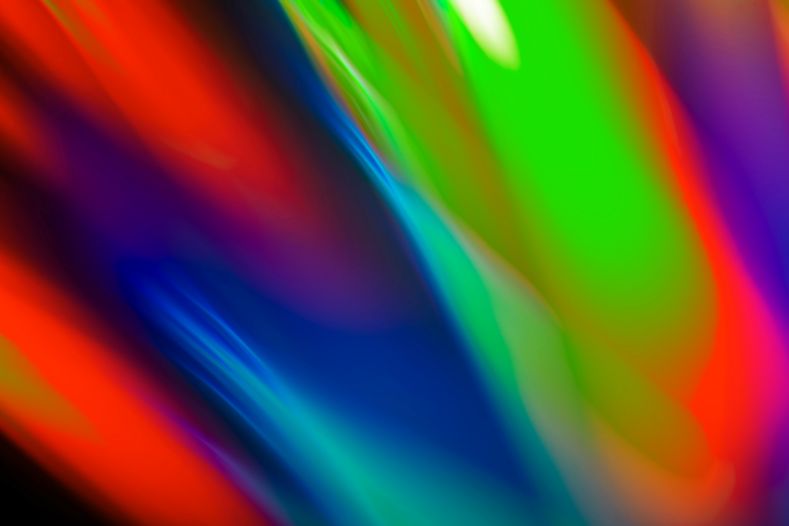 A vibrant and colorful abstract background with gradients of red, green, blue, and purple, blending smoothly with reflections, representing a dynamic and modern design.