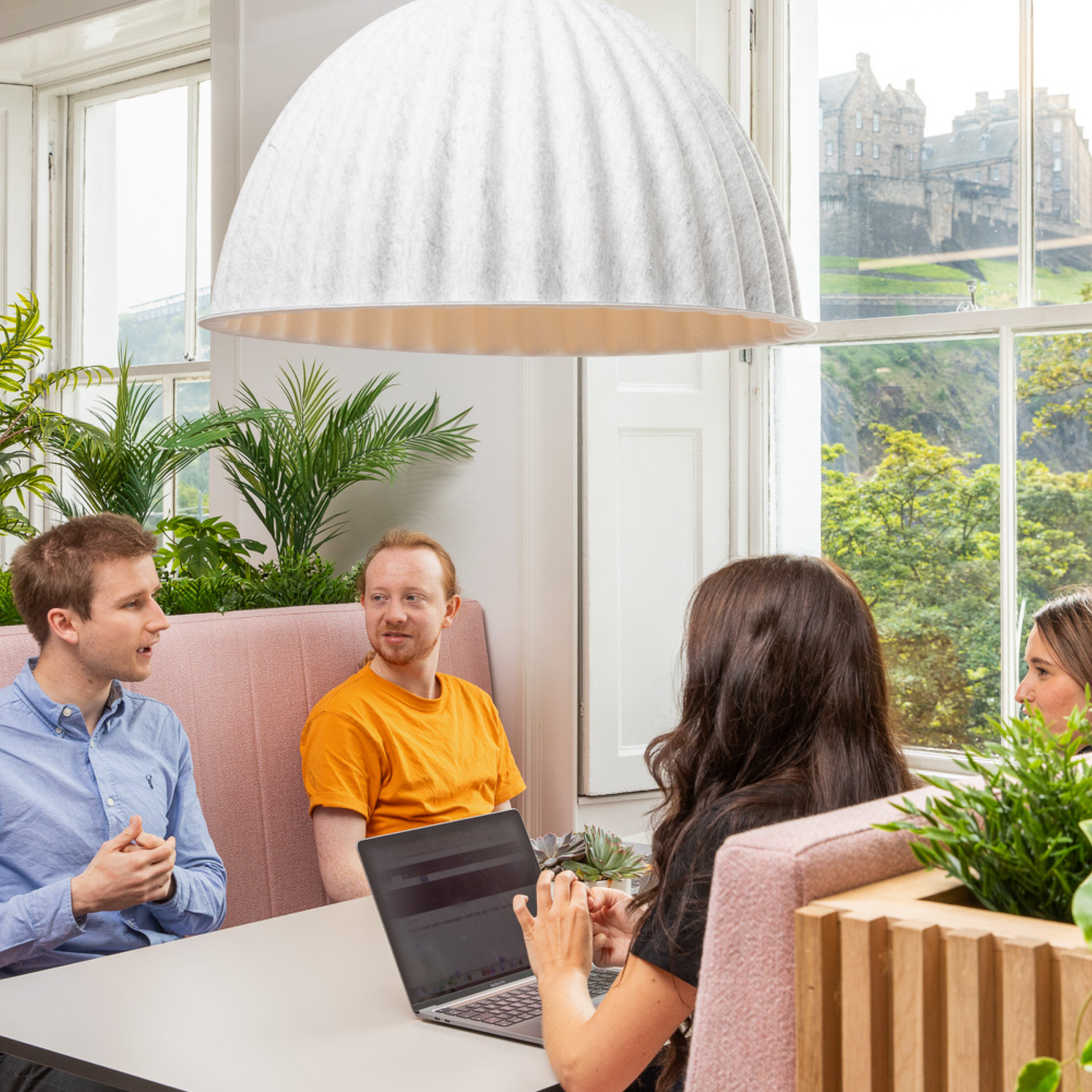 A group of people sitting at a table with a laptop