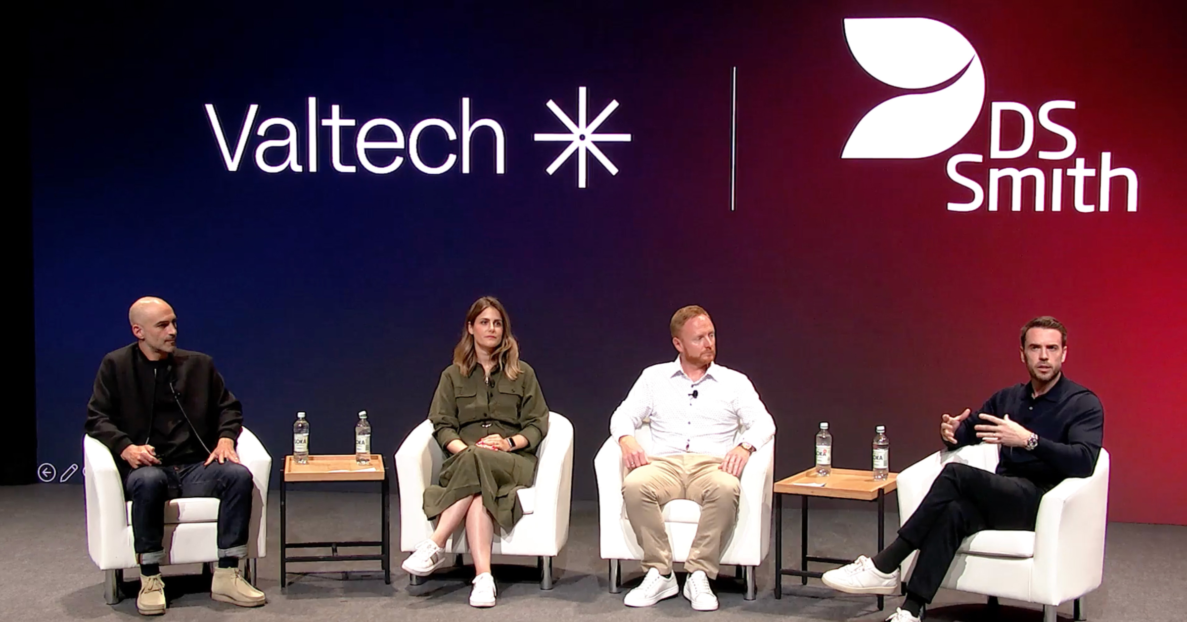 A panel of four professionals speaking at a Valtech and DS Smith event, seated on stage with logos in the background, discussing digital transformation.