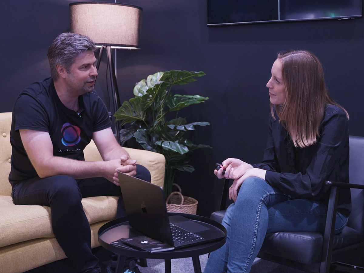 Two colleagues in a casual interview, with a laptop on the coffee table.